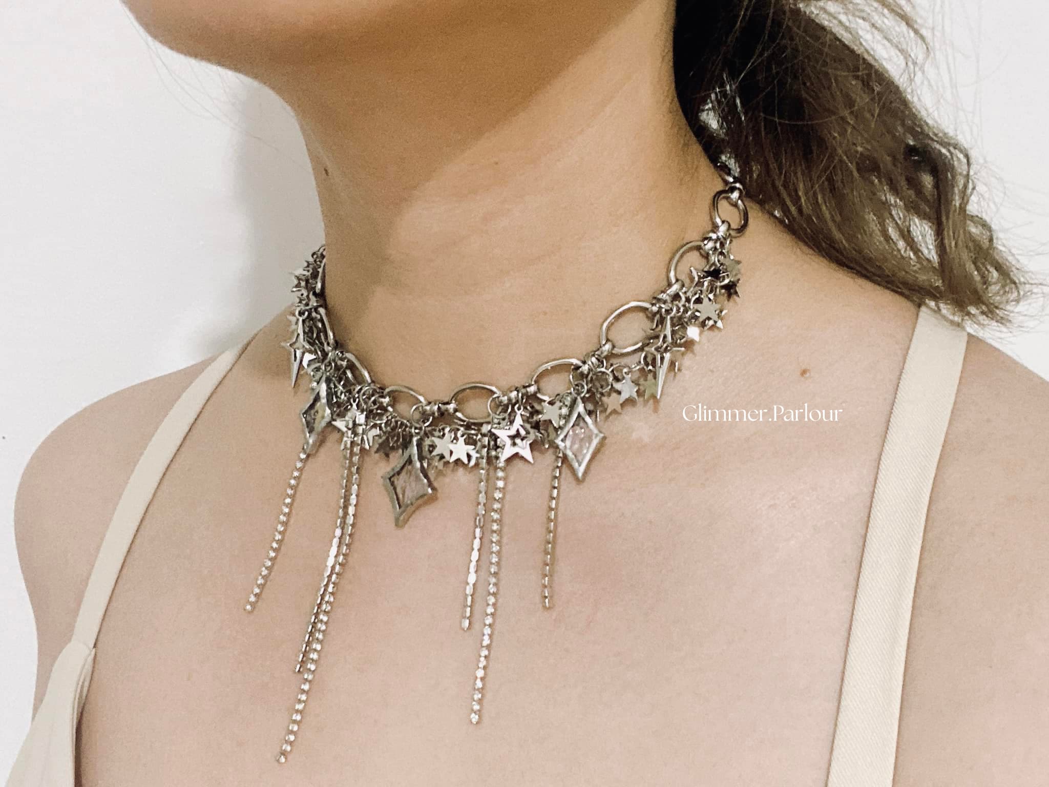 Silver-toned necklace with star and diamond charms and long, sparkling dangling chain fringes.